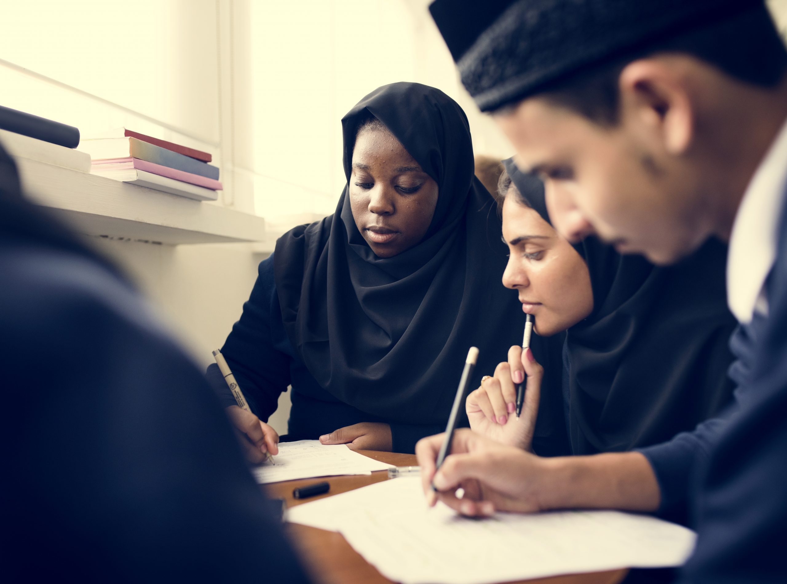 Diverse Muslim children studying in classroom